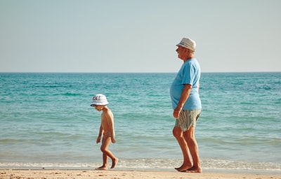 男人穿蓝色衬衫站在海滨附近的男孩白帽子
